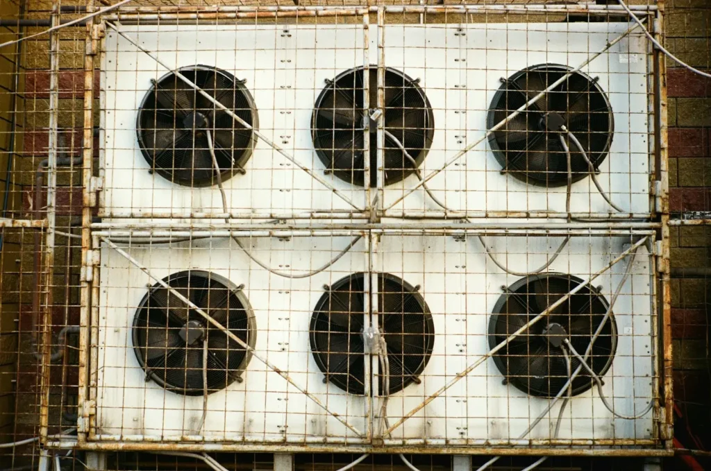 Six industrial fans mounted on a white grid structure.