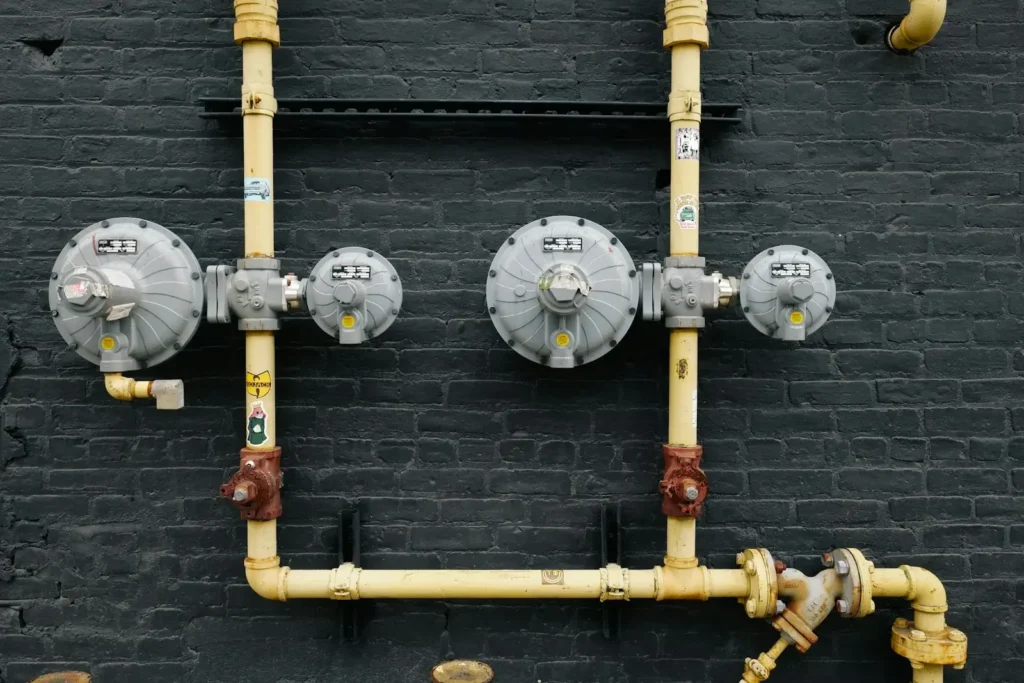 Pipes and equipment are mounted on a black wall.
